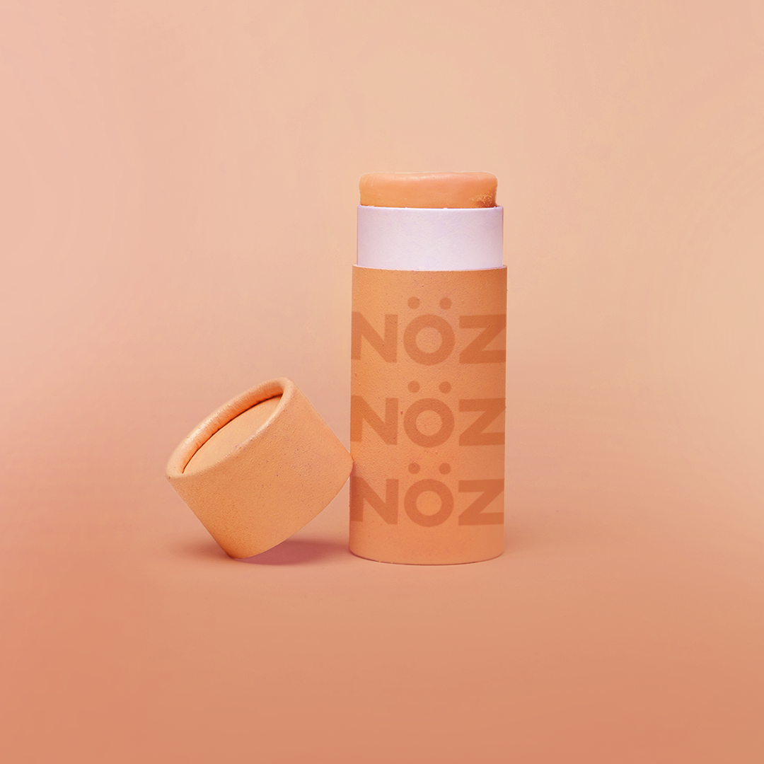 Front view of SPF15 Nöz organic sunscreen in an opened orange colored tube.