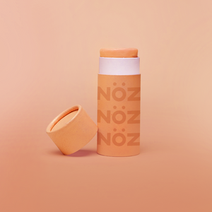 Front view of SPF15 Nöz organic sunscreen in an opened orange colored tube.